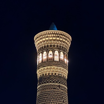 The top of a minaret lit up at night